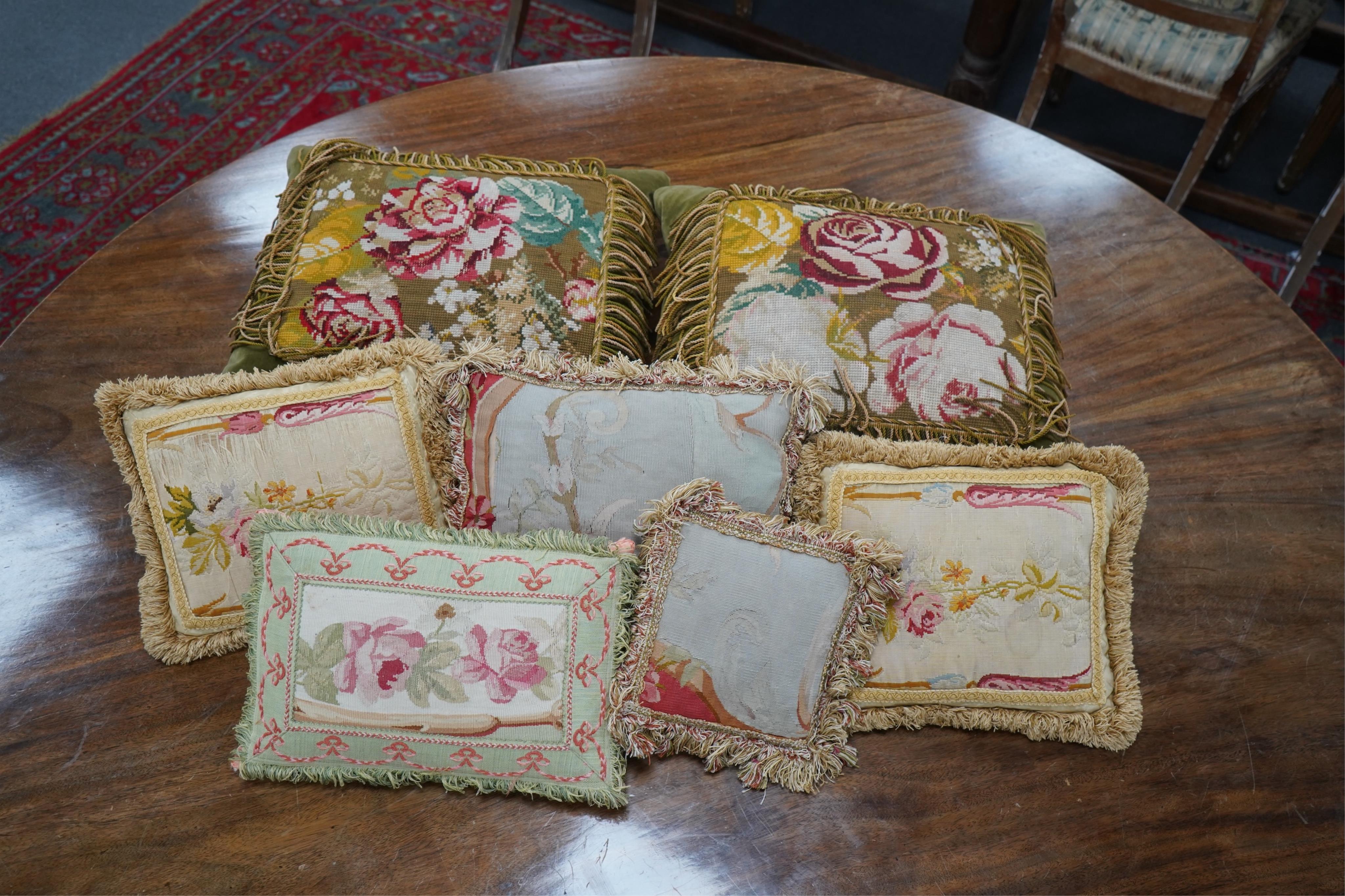 Seven 19th century cushions. Three Aubusson tapestry cushions and two machine Aubusson cushions, together with two floral wool worked cushions, all with decorative fringing. Largest 40cm x 45cm. condition - three are wor